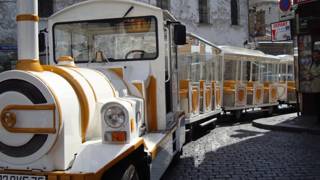 Tourist train on cobblestone street in Montmartre, Paris.