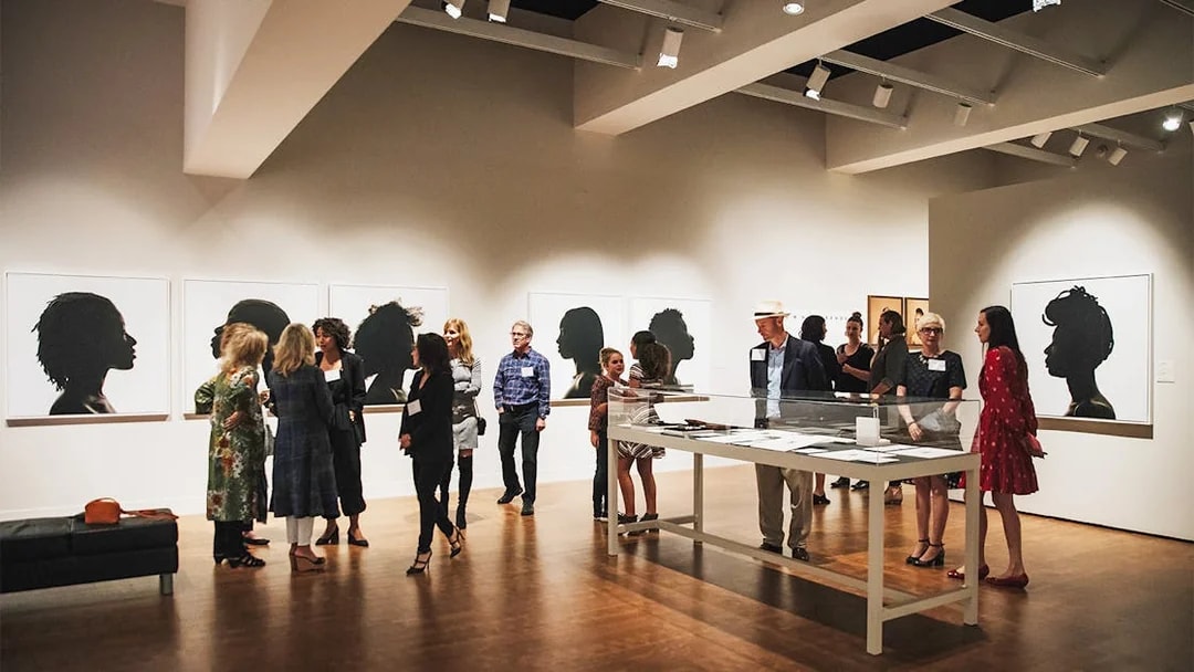 Art gallery visitors viewing silhouette portraits, San Diego All-Inclusive Pass.