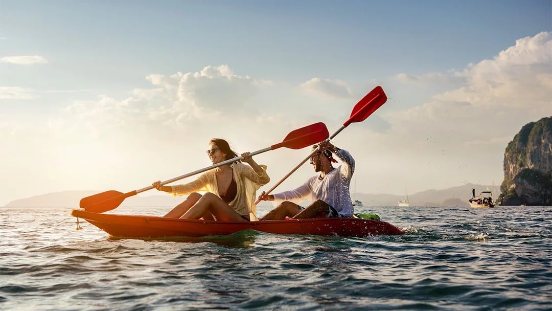 Two people kayaking on the ocean near cliffs, San Diego All-Inclusive Pass.