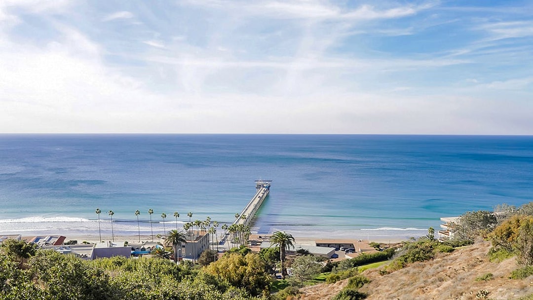 San Diego coastline with pier extending into the ocean, view from hillside.