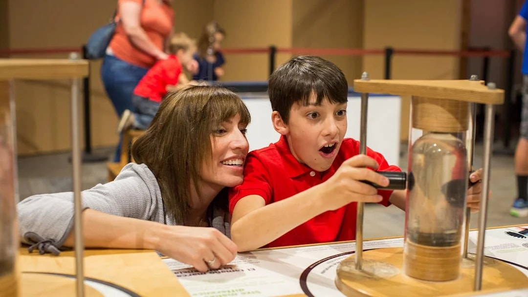 Child exploring interactive exhibit at San Diego science museum.