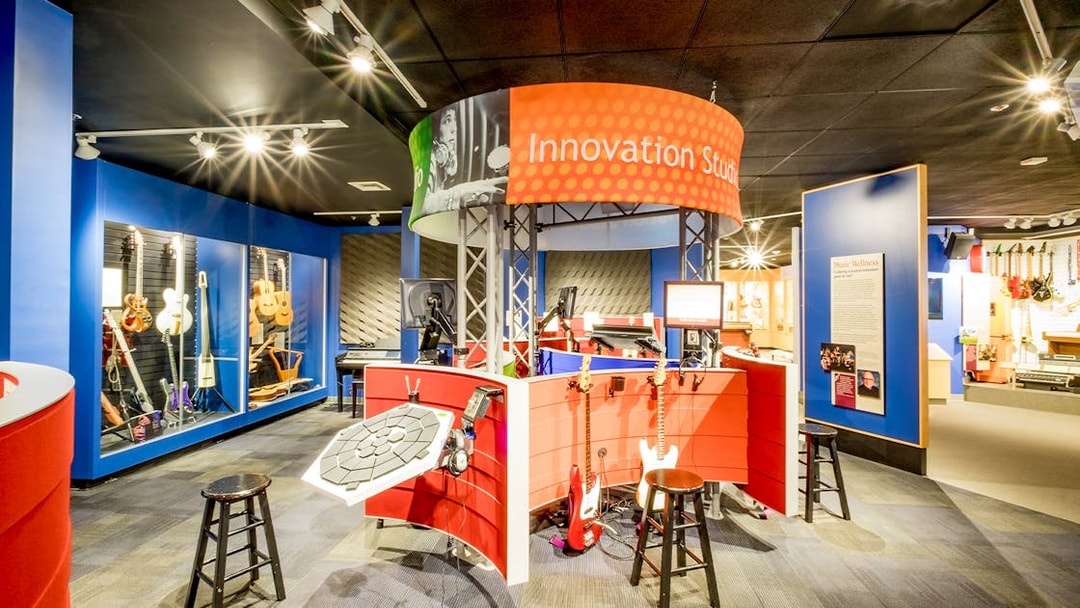 Innovation Studio with guitars and music equipment display in San Diego museum.
