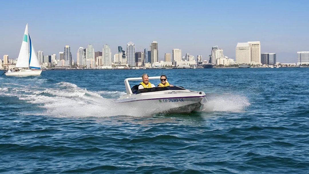 Speedboat on San Diego Bay with city skyline in the background, part of San Diego Explorer Pass.