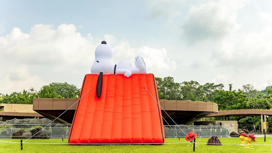 Snoopy inflatable tent at Singapore Zoo with surrounding greenery.