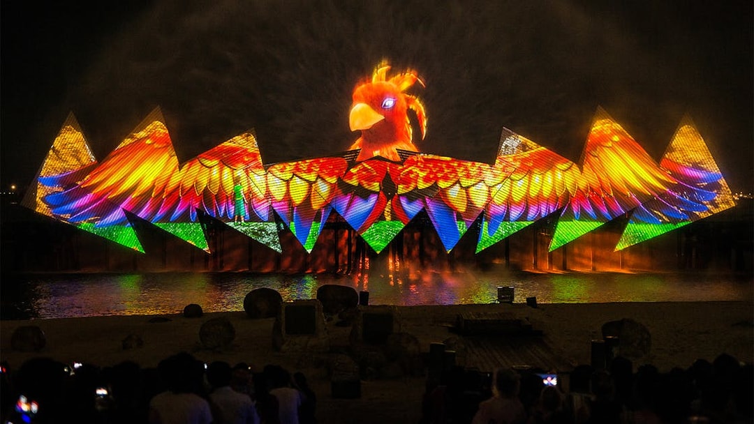 Wings of Time night show with colorful lights and bird projection at Sentosa Island.