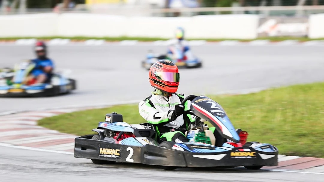 Go-kart racing at Morac Adventure Park, Langkawi, with driver navigating a track curve.