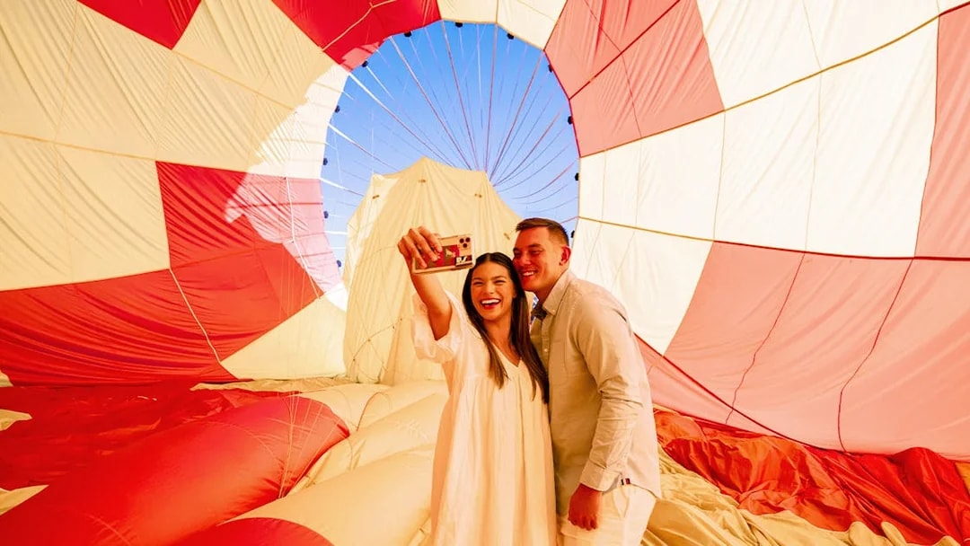 Couple taking a selfie inside a hot air balloon during Gold Coast Classic Ballooning tour.