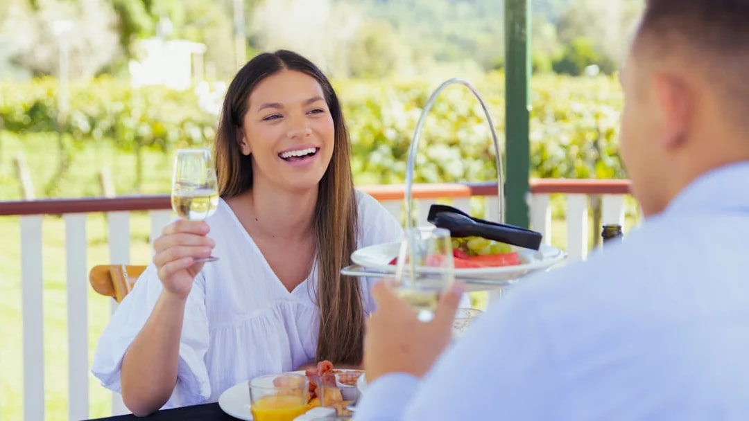 Woman enjoying champagne breakfast at vineyard in Gold Coast.