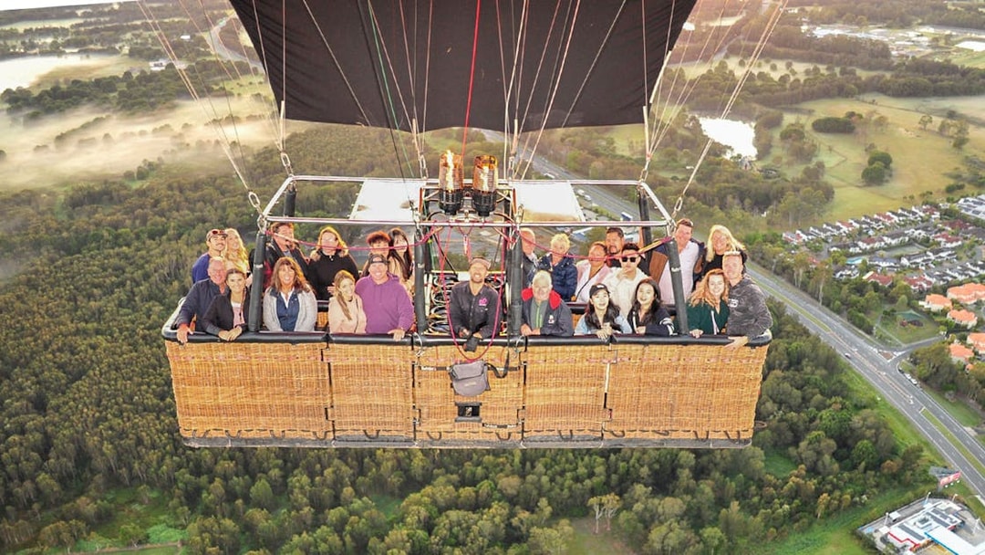 Group enjoying a hot air balloon flight over scenic landscape with optional transfers.