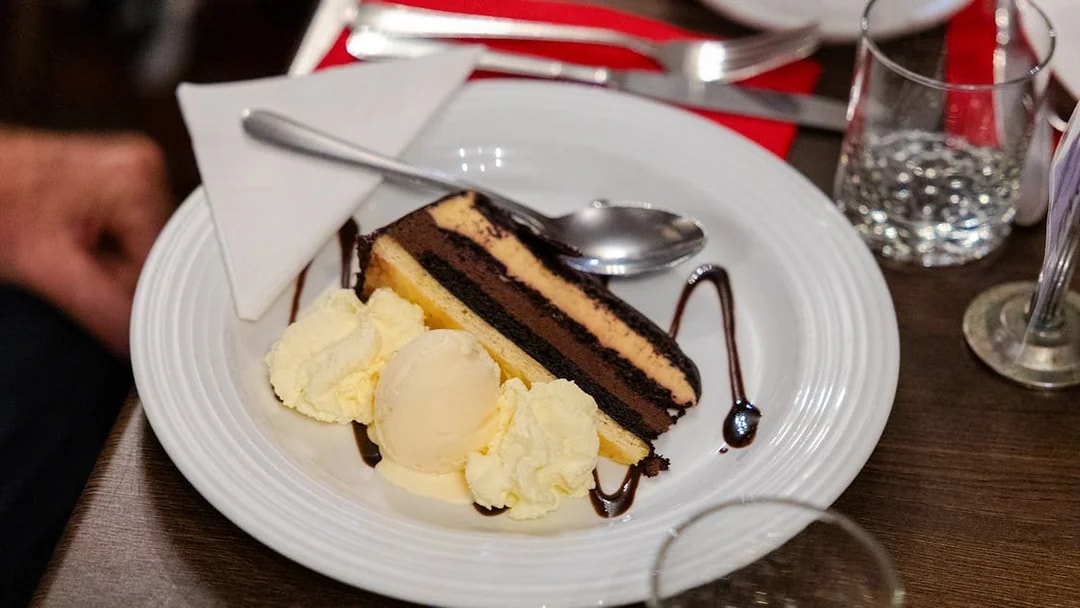 Chocolate cake with ice cream served on a plate during the Evening Rainforest & Glow Worm Experience.