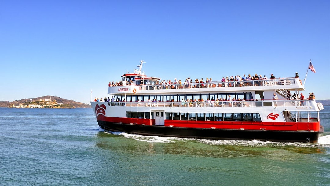 Cruise ship with passengers sailing near Alcatraz Island on San Francisco Bay, USA.