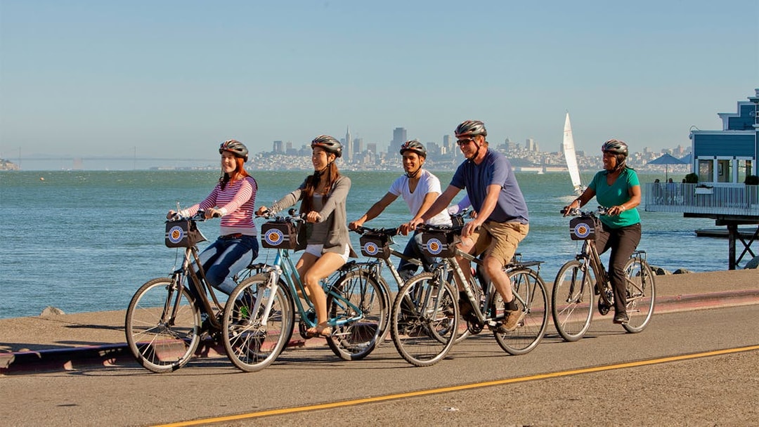 Cyclists on a guided tour from Golden Gate Bridge to Sausalito with San Francisco skyline.