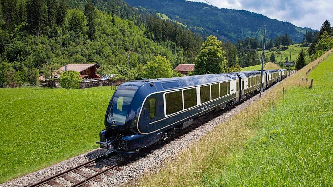 GoldenPass Express train traveling through lush Swiss countryside.