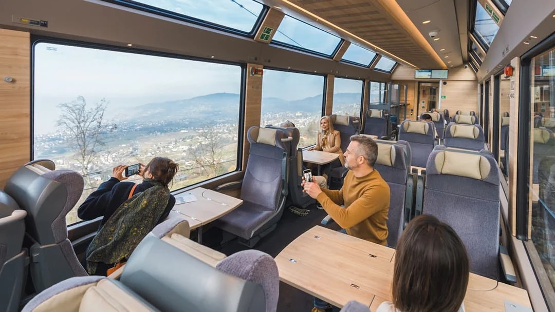 Passengers enjoying panoramic views on the GoldenPass Express train from Montreux to Interlaken.