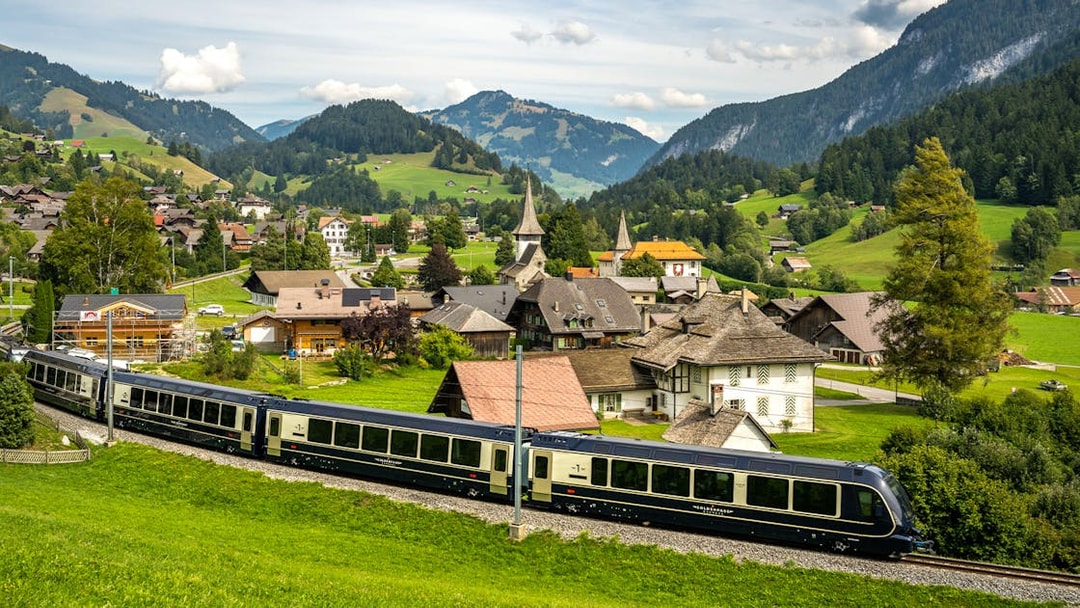 Scenic view of the GoldenPass Express train passing through a Swiss village near Interlaken and Gstaad.