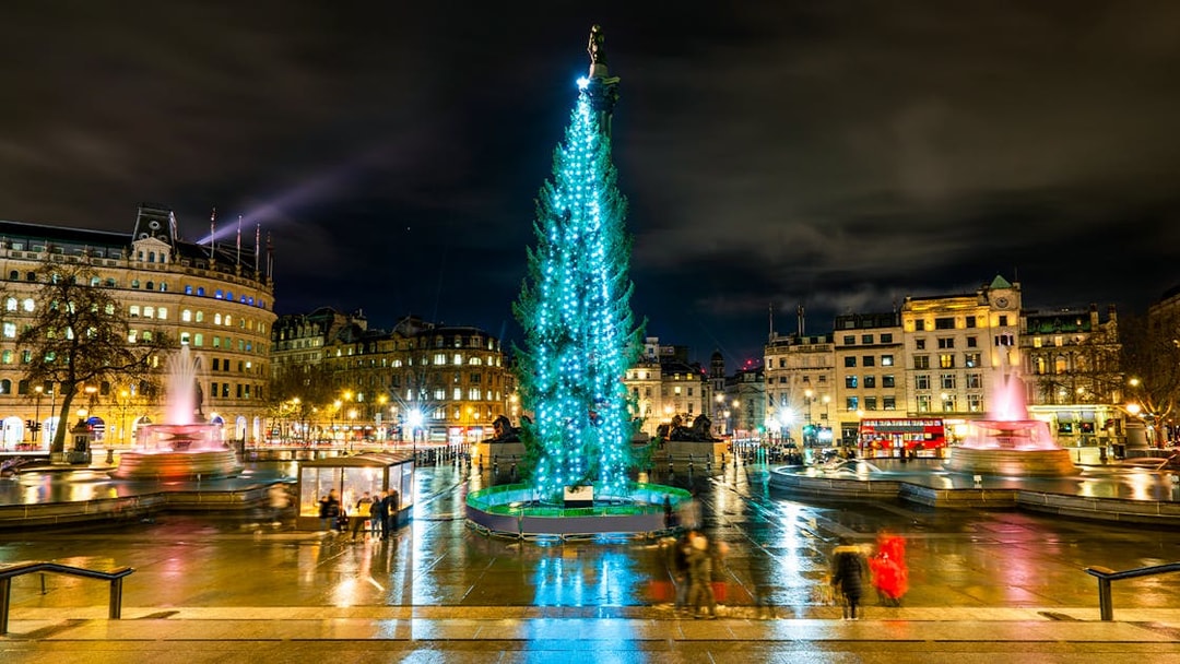 Trafalgar Square at night with Christmas tree and fountains, London, England.