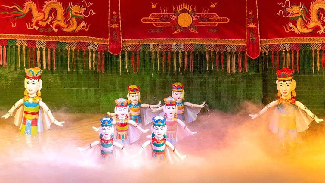 Water puppets performing on stage with colorful backdrop in Vietnam.
