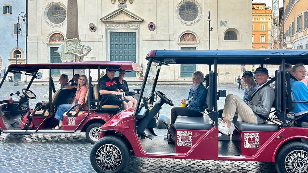 Golf carts with tourists in front of a historic building in Rome.