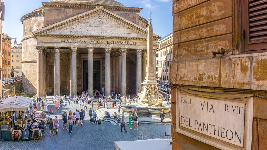 Pantheon in Rome with tourists and fountain in the foreground.
