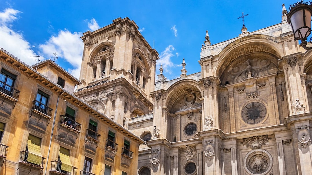 Granada Cathedral facade with ornate architectural details under a clear blue sky.