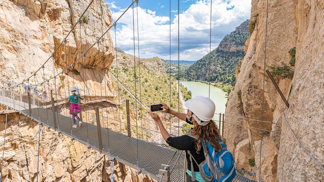 Visitors crossing suspension bridge on Caminito del Rey trail, Málaga, Spain.