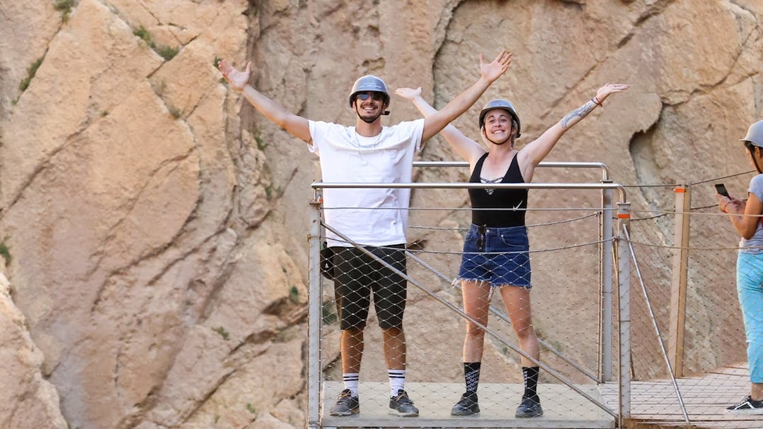 Tourists on a platform at Caminito del Rey with mountain backdrop, Malaga.