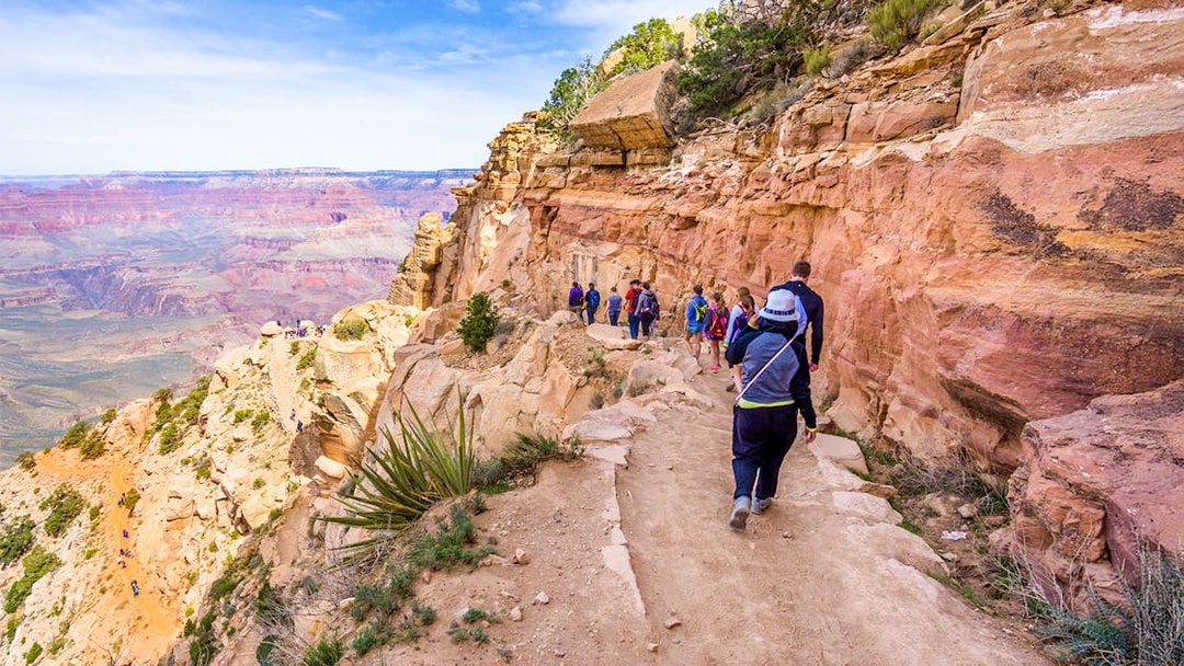 Guests walking along a trail with a view of the Grand Canyon West, Arizona.