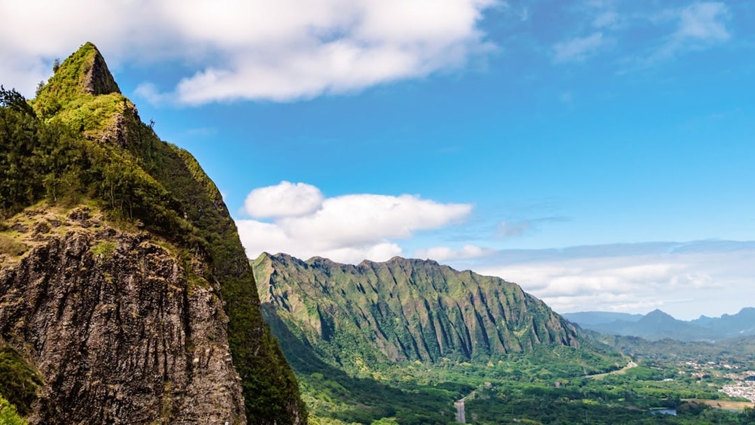 Nuuanu Pali Lookout view of lush green mountains and valley in Oahu, Hawaii.