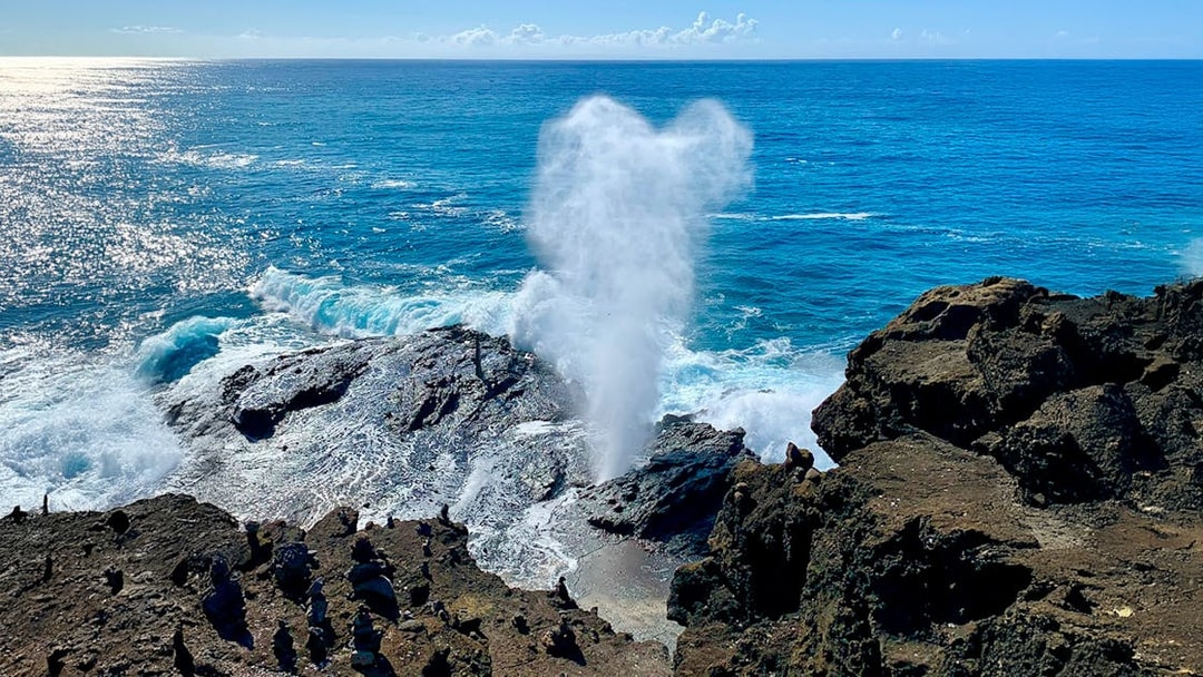 Halona Blowhole spouting water against rocky coastline, Oahu, Hawaii.