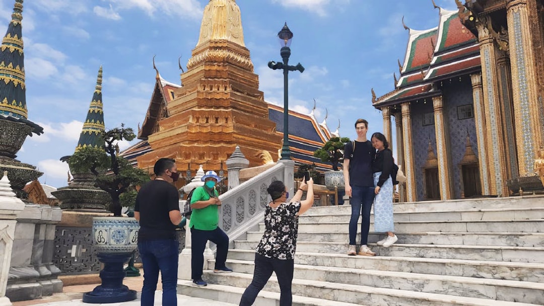 Visitors at Grand Palace, Bangkok, posing for photos near Wat Phra Kaew during a walking tour.