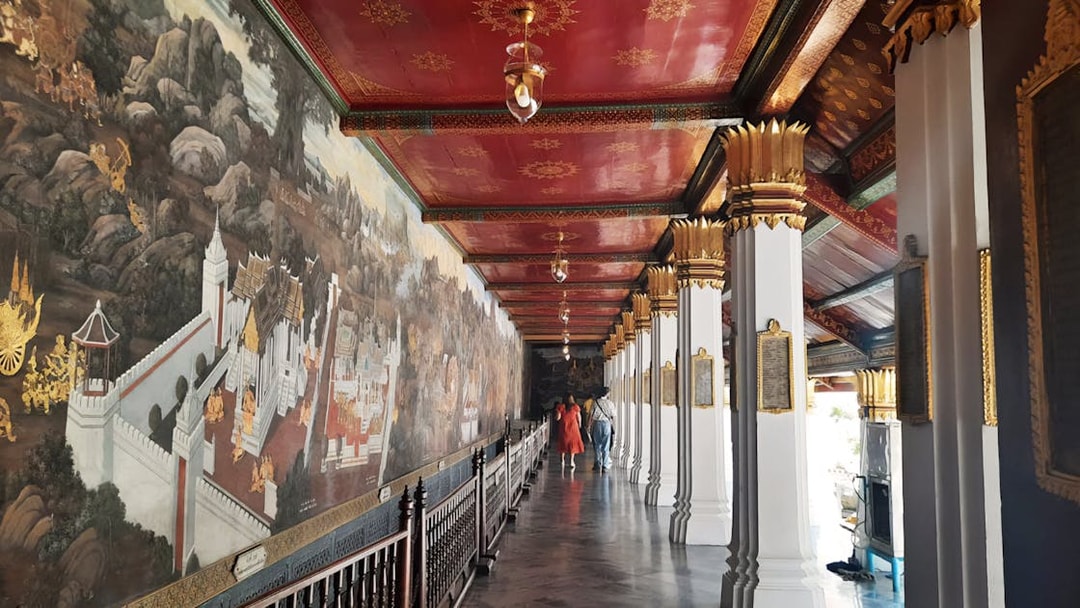 Grand Palace mural corridor with intricate artwork, Bangkok, part of Wat Phra Kaew walking tour.
