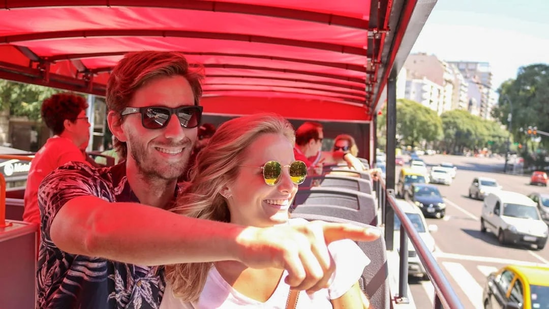 Couple enjoying city views from HOHO bus in Buenos Aires.