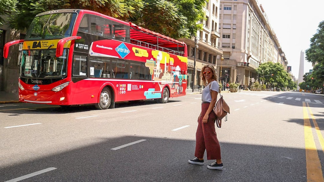 Woman crossing street near Buenos Aires hop-on hop-off bus.