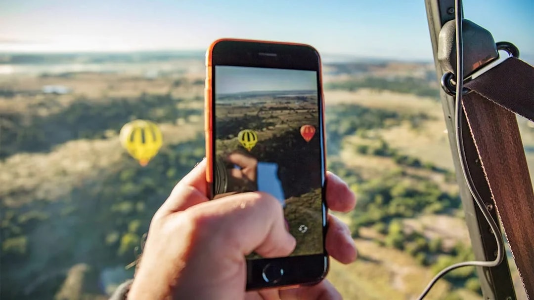 Hot air balloons over Greater Brisbane landscape captured on a smartphone.