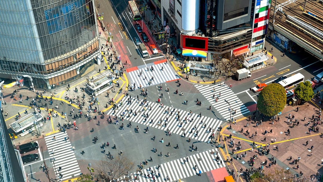 Shibuya Crossing in Tokyo bustling with pedestrians from an aerial view.