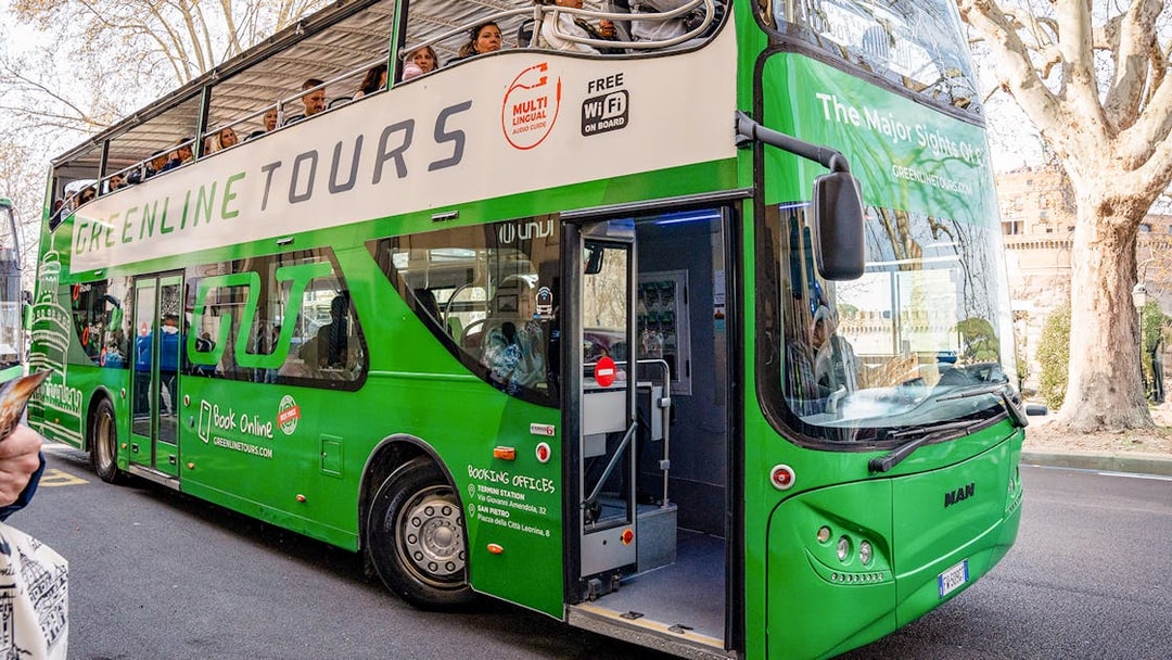 Green Line hop-on hop-off bus in Rome with passengers on the upper deck.