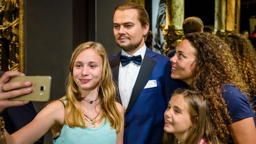 Visitors taking a selfie with a wax figure at Grévin Paris Wax Museum.