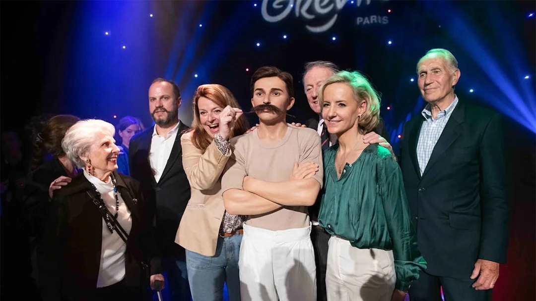 Group posing with Pierre de Coubertin wax figure at Grévin Paris.