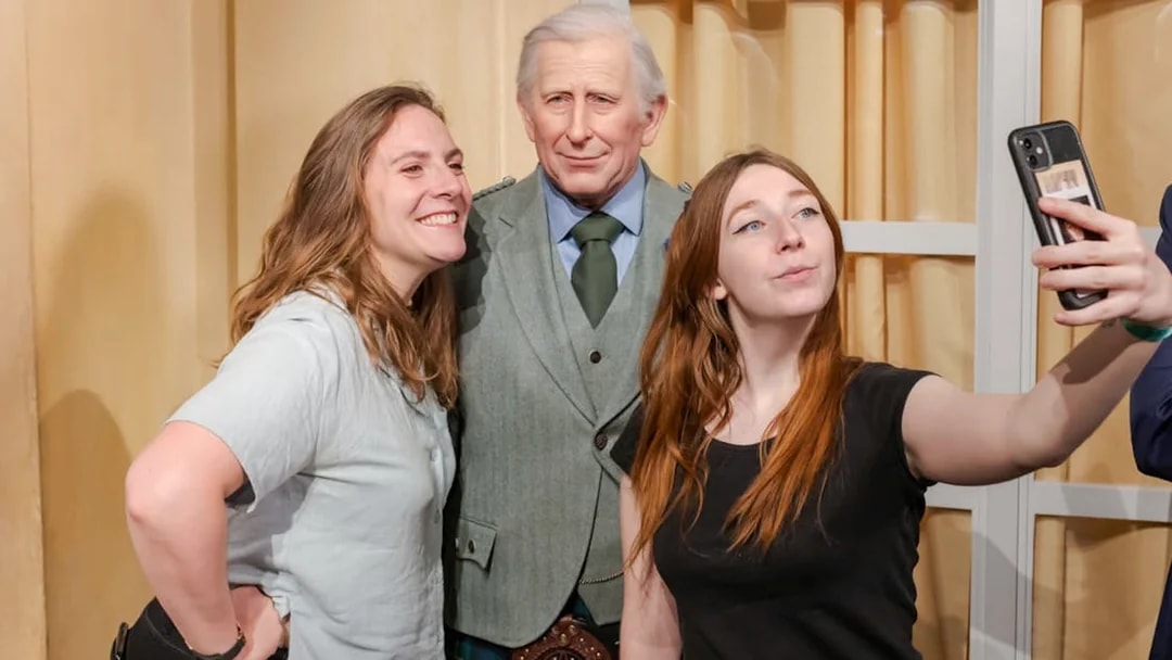 Visitors taking a selfie with a wax figure at Grévin Paris Wax Museum.