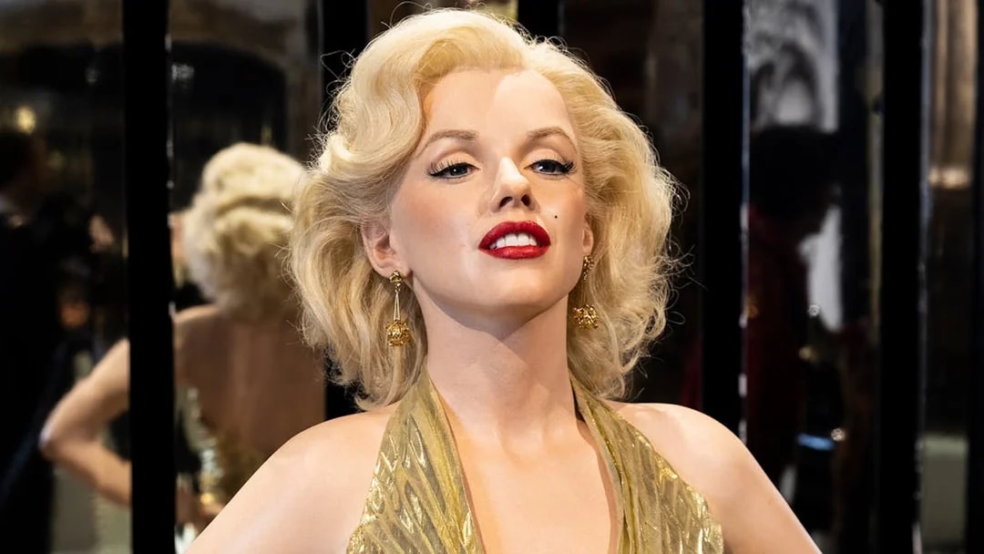 Wax figure of a famous actress in a gold dress at Grévin Paris Wax Museum.