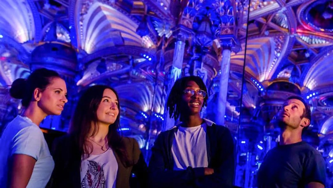 Visitors admire ornate ceiling at Grévin Paris Wax Museum.