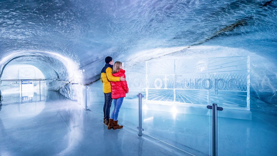 Couple exploring Ice Palace at Jungfraujoch, Switzerland.