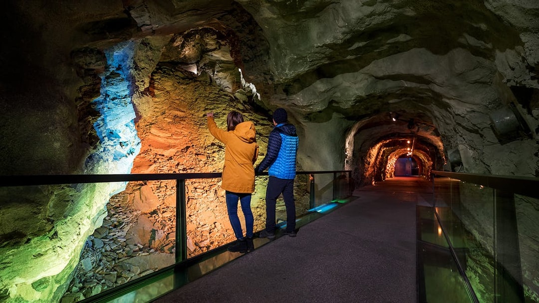 Visitors exploring illuminated tunnel at Jungfraujoch, Switzerland.