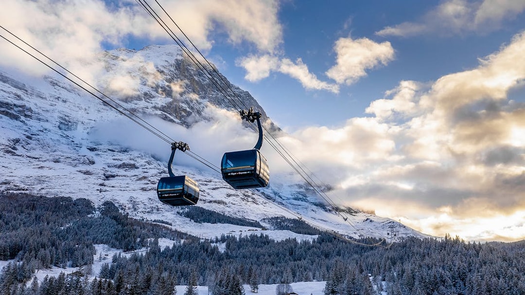 Cable cars ascending snowy mountains from Grindelwald to Jungfraujoch.