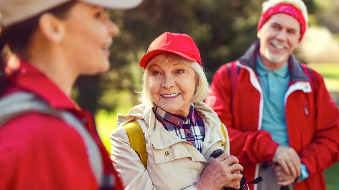 Blonde woman smiling while listening to a guide during a group hike.
