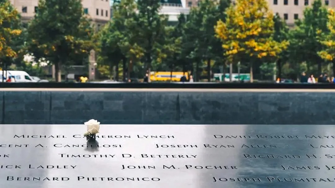 Names engraved on the 9/11 Memorial with a white rose, New York City.