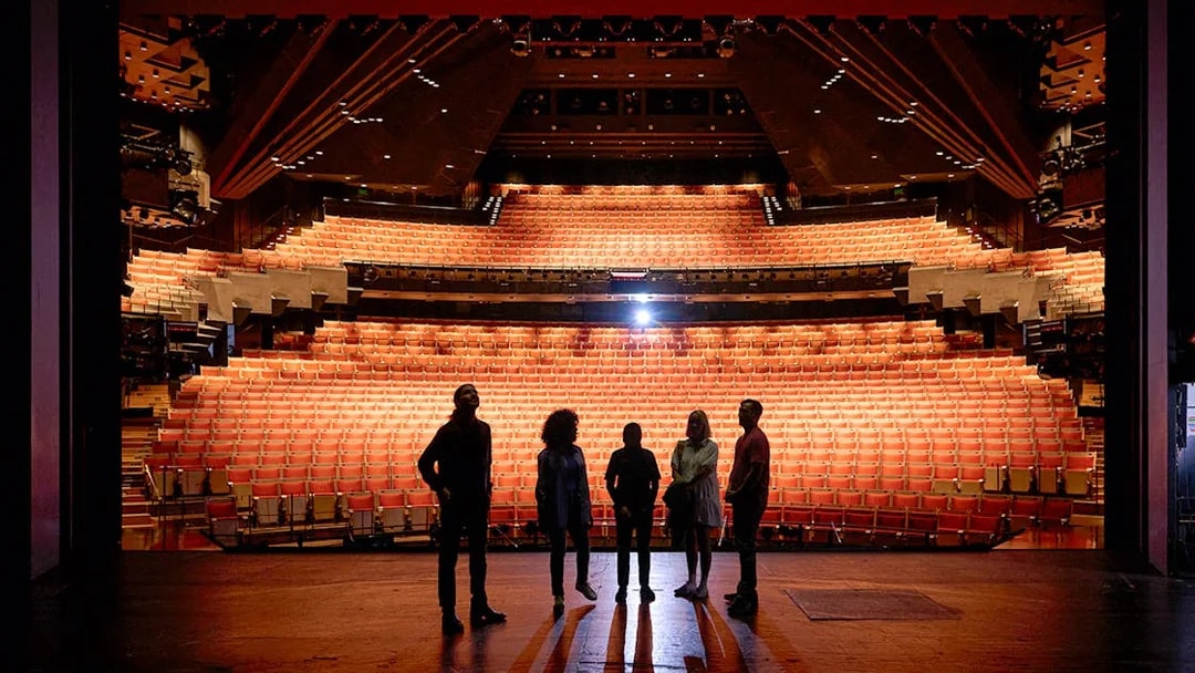 Backstage view of Sydney Opera House with group on stage during guided tour.