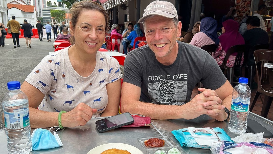 Couple enjoying local snacks at an outdoor cafe during the Bike and Bites Food Tour.