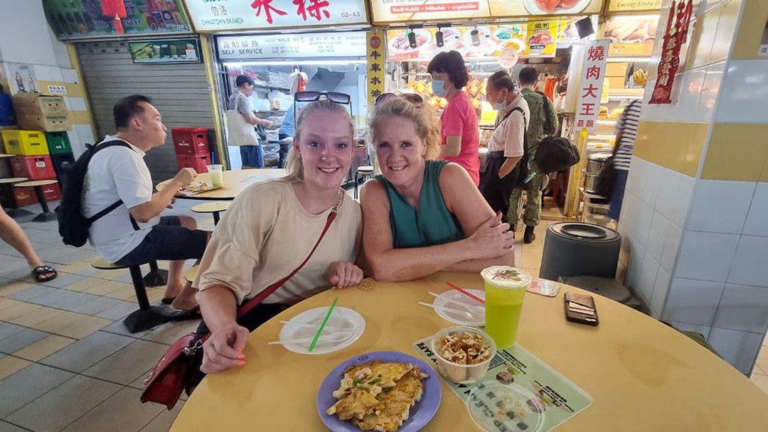 Visitors enjoying local cuisine at a food stall during the Bike and Bites Food Tour.