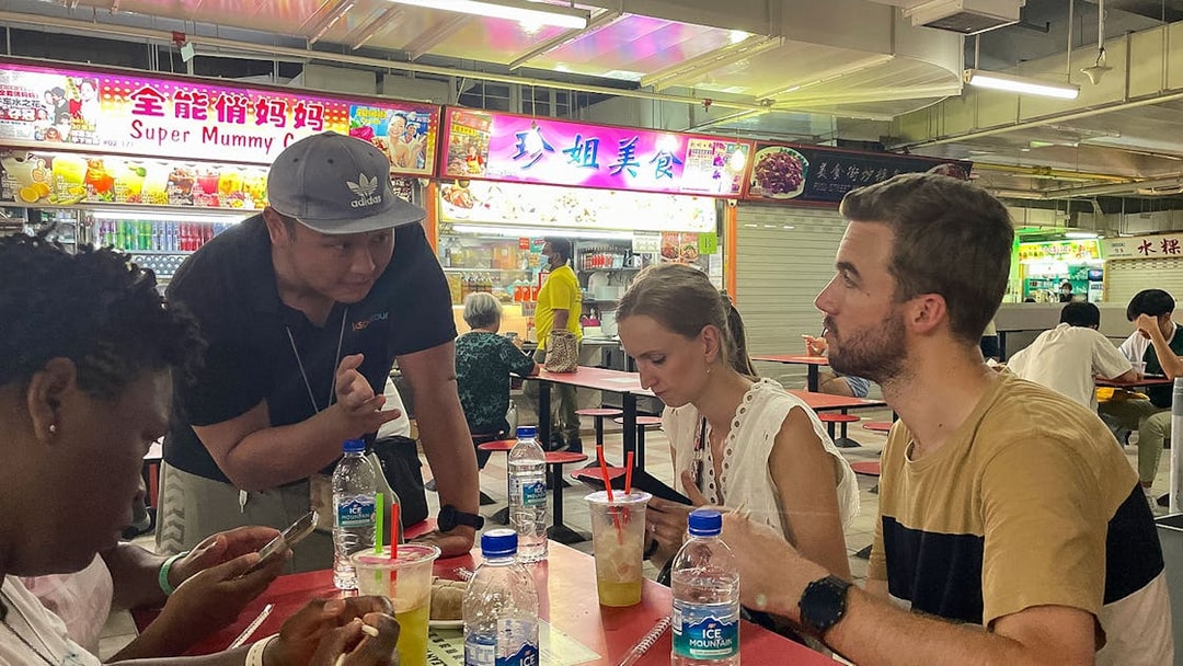 Group enjoying local food at a hawker center during Bike and Bites Food Tour.